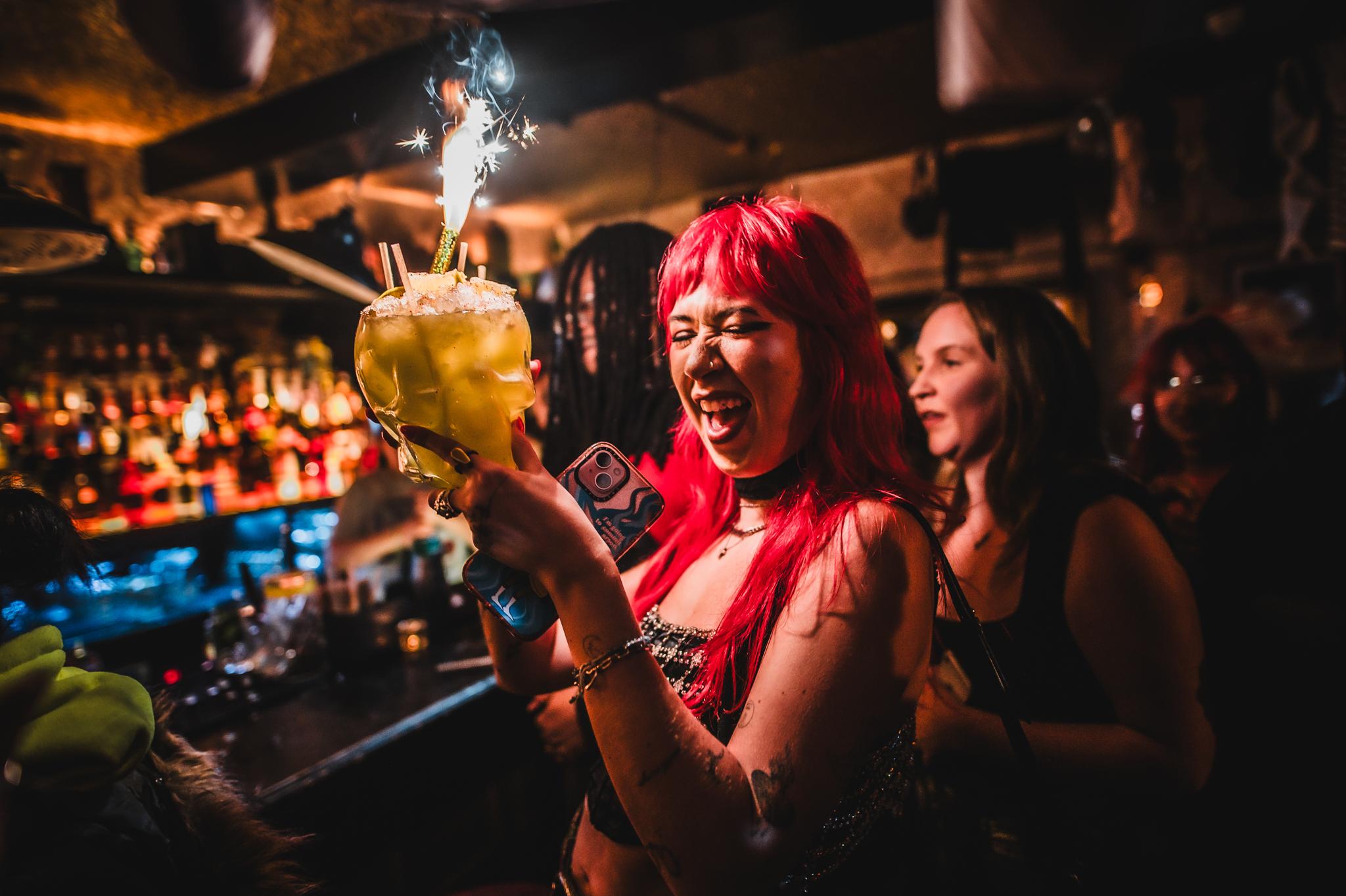 Woman holding a cocktail sharer with a sparkler